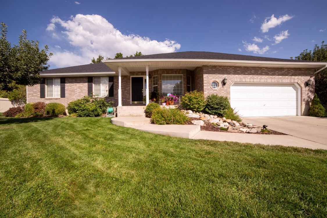 Illustrative exterior of a single-story suburban brick house with a front lawn.